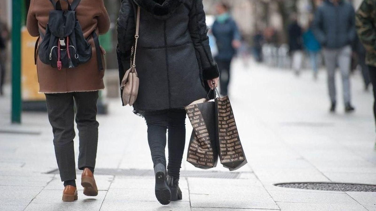 Dos ourensanos, en la rúa do Paseo, con bolsas de un comercio