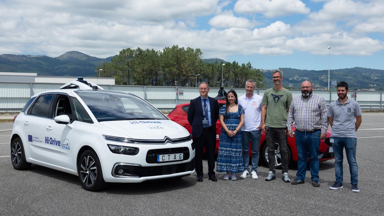 Responsables del proyecto con dos prototipos de vehículos autónomos en las instalaciones de CTAG.