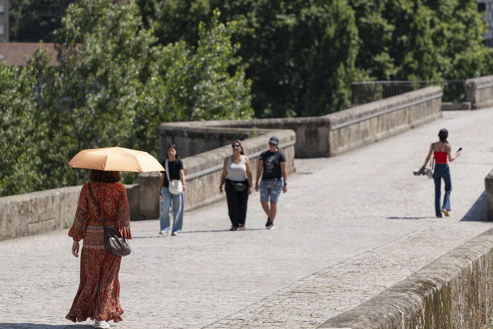 Galería | Viajeros, peregrinos y ourensanos viven una jornada de intenso calor en Ourense, en fotos