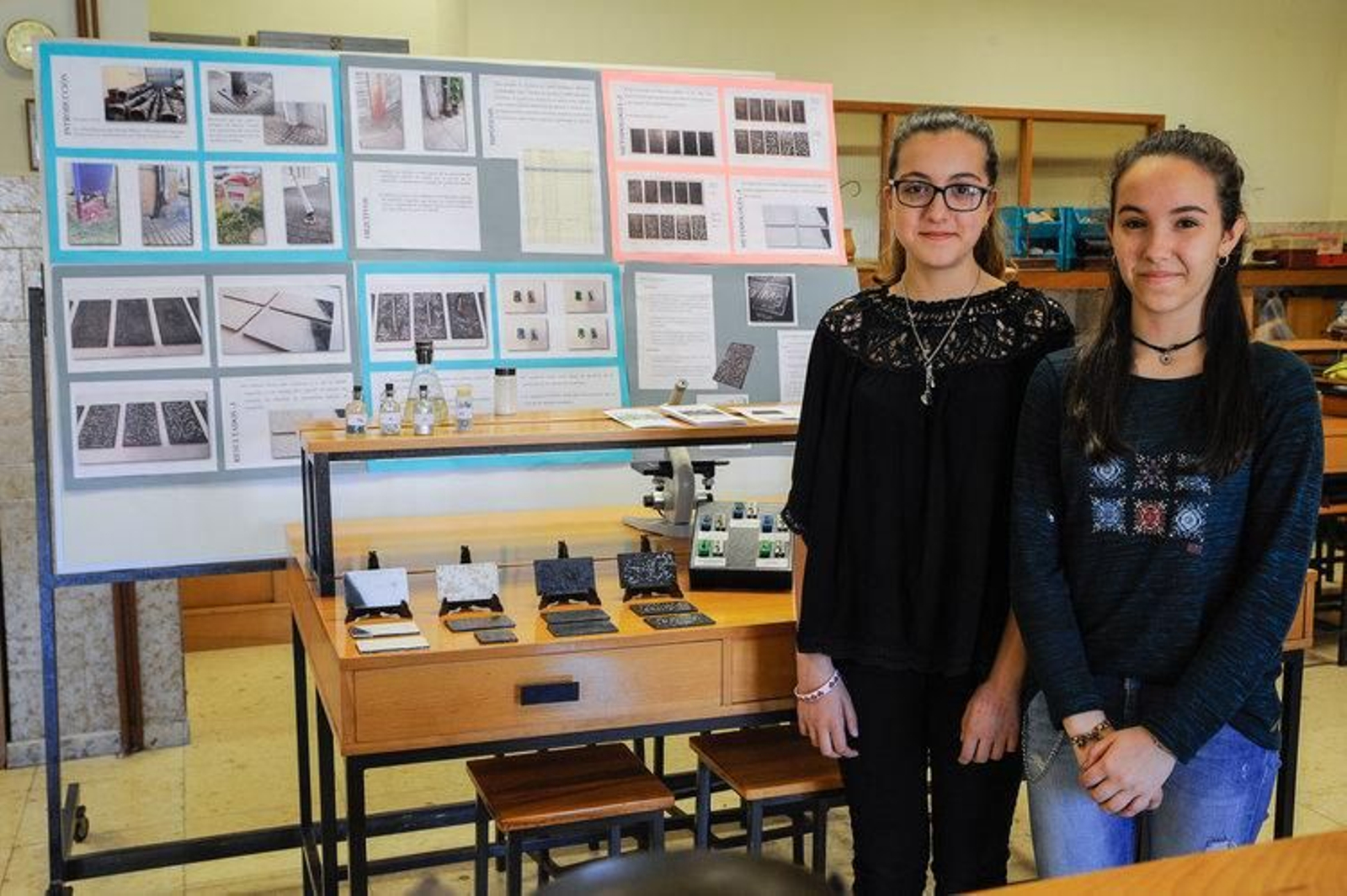 Alicia Gómez Ceballos y Paula Pérez Rodríguez, ante el panel que recoge su proyecto de investigación.