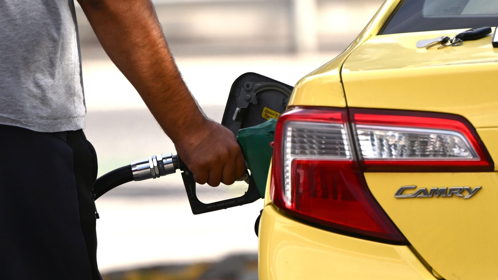 Una persona repostando combustible en su vehículo.