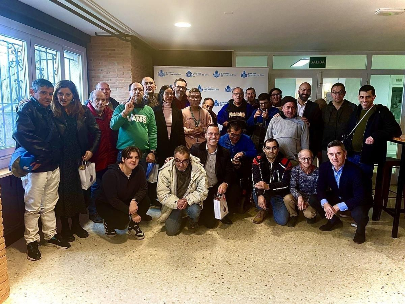 Foto de familia de un grupo de usuarios con los candidatos del PP en Hogar y Clínica San Rafael.
