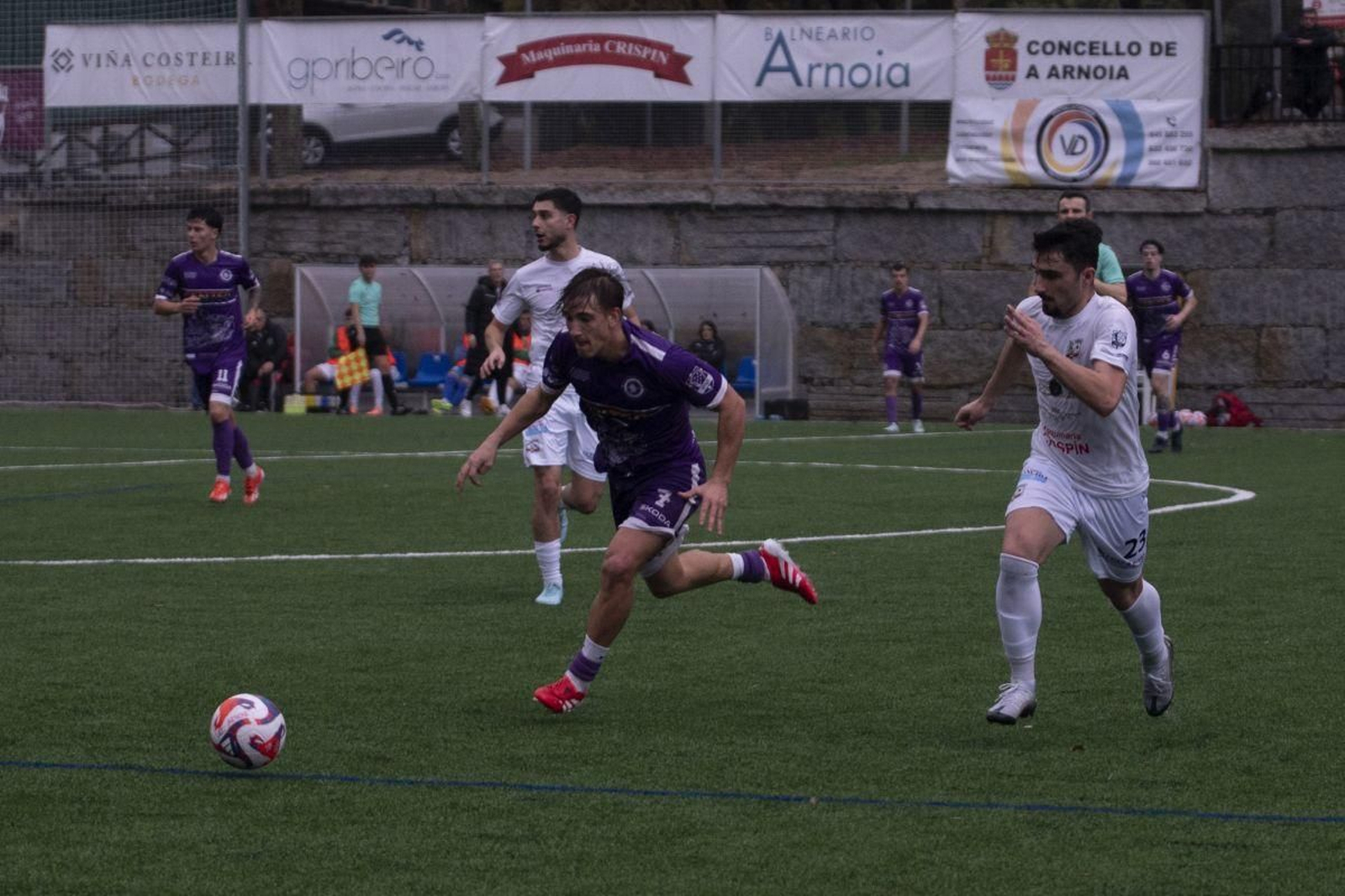 Izan, defensa del Cented, corre a por el balón ante Charly, lateral izquierdo del Atlético Arnoia.