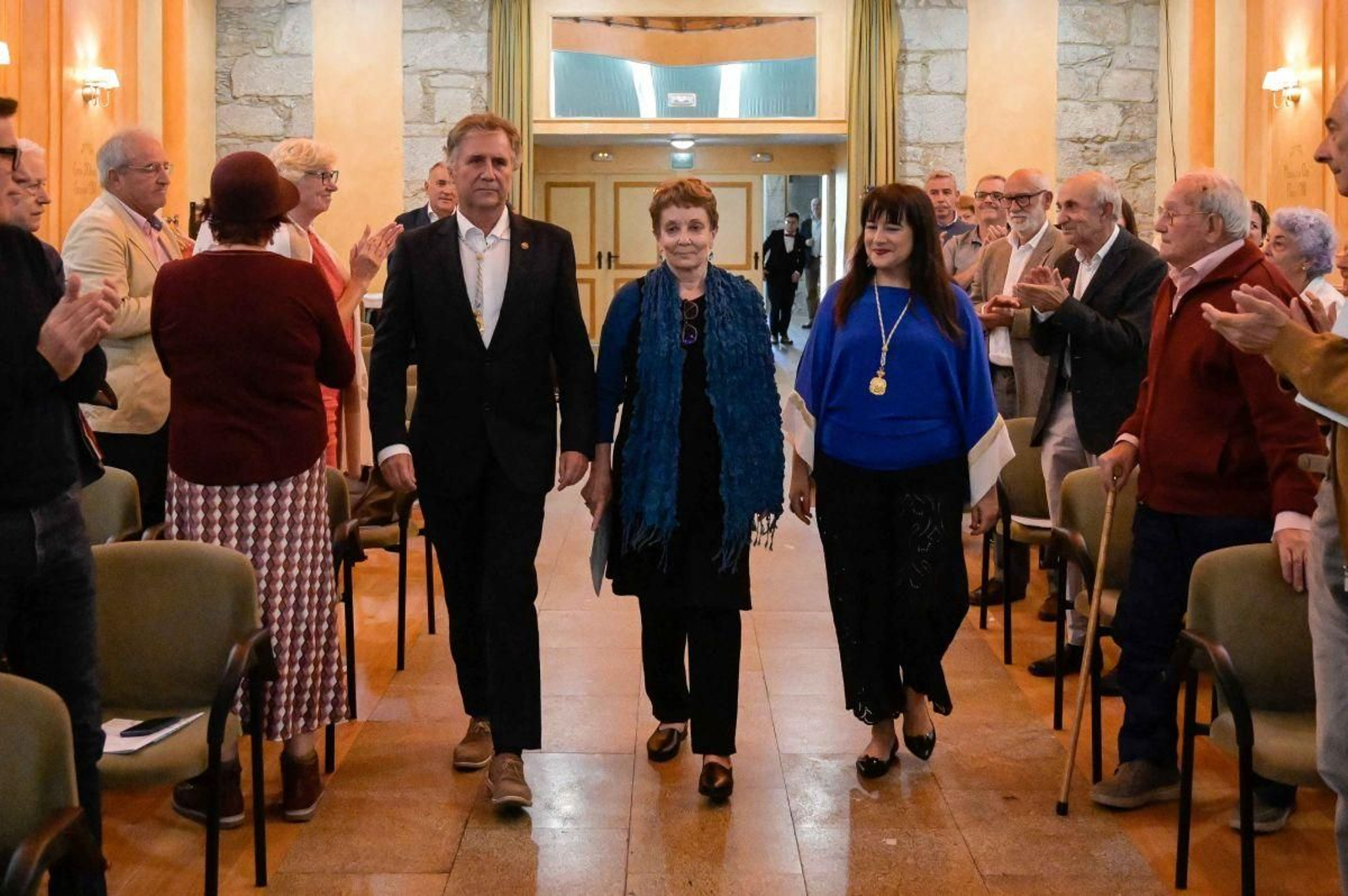 Kathleen March, no centro, entra no Balneario de Mondariz, un século despois da ceremonia de ingreso de Ramón Cabanillas no mesmo espazo.