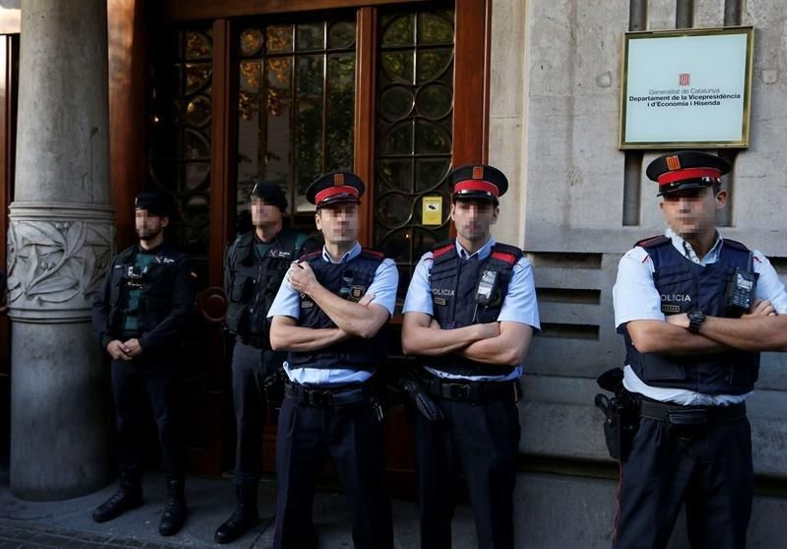 Agentes de la Guardia Civil y de los Mossos d'Esquadra en la puerta de la consellería de Economía de la Generalitat
