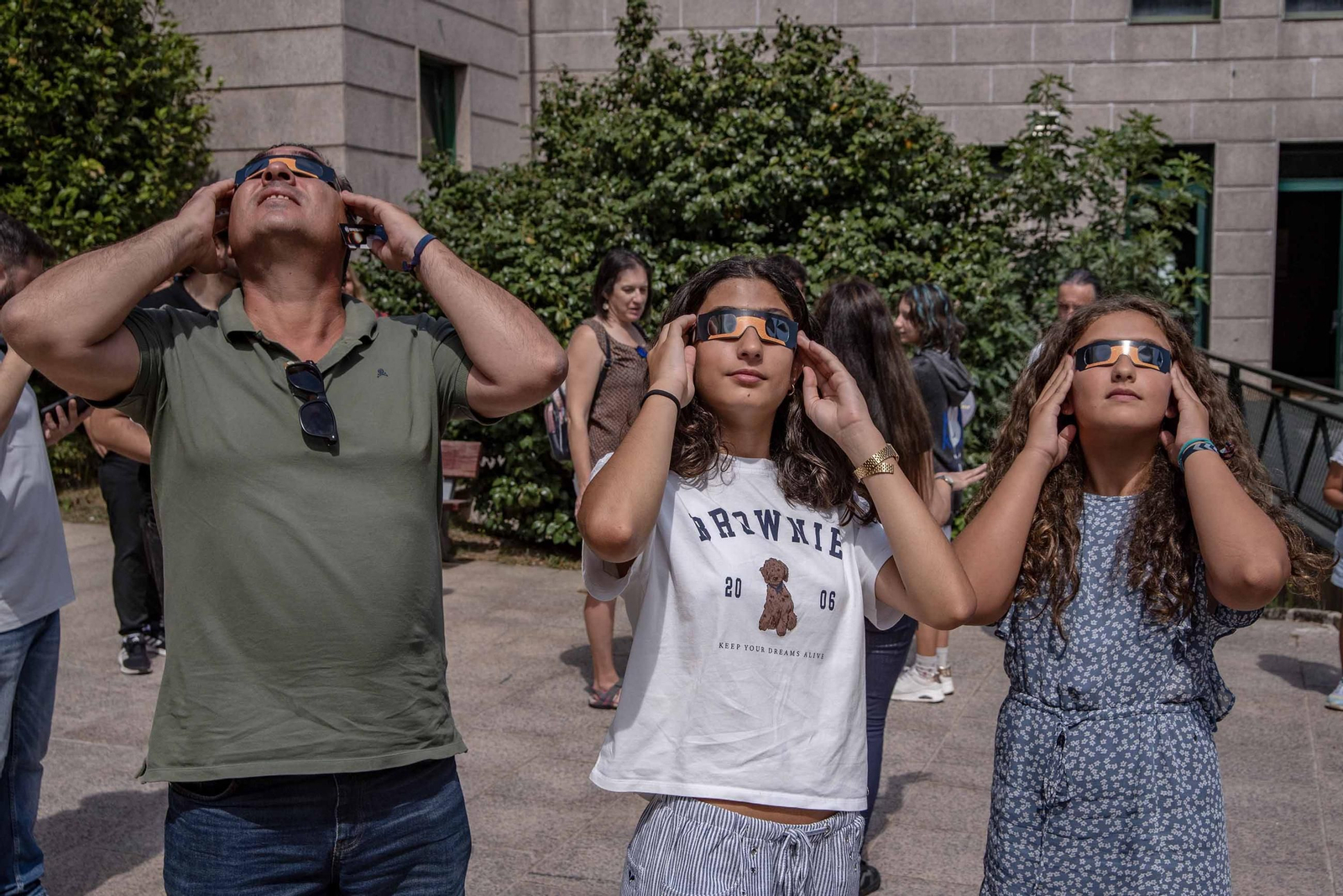 Tres personas prueban las gafas que se deberán utilizar para ver el eclipse.
