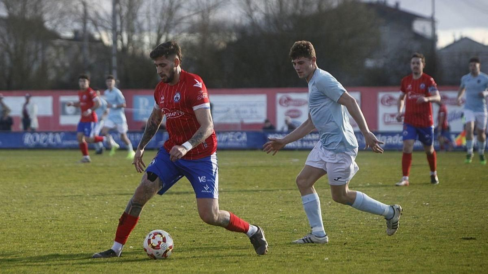 El defensa verinense Jorge Aires protege la pelota ante un delantero del Beluso.
