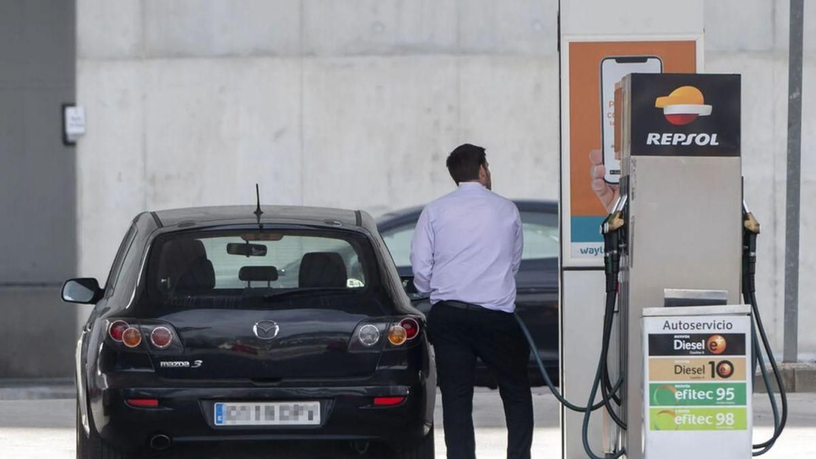 Un hombre reposta carburante en una gasolinera.