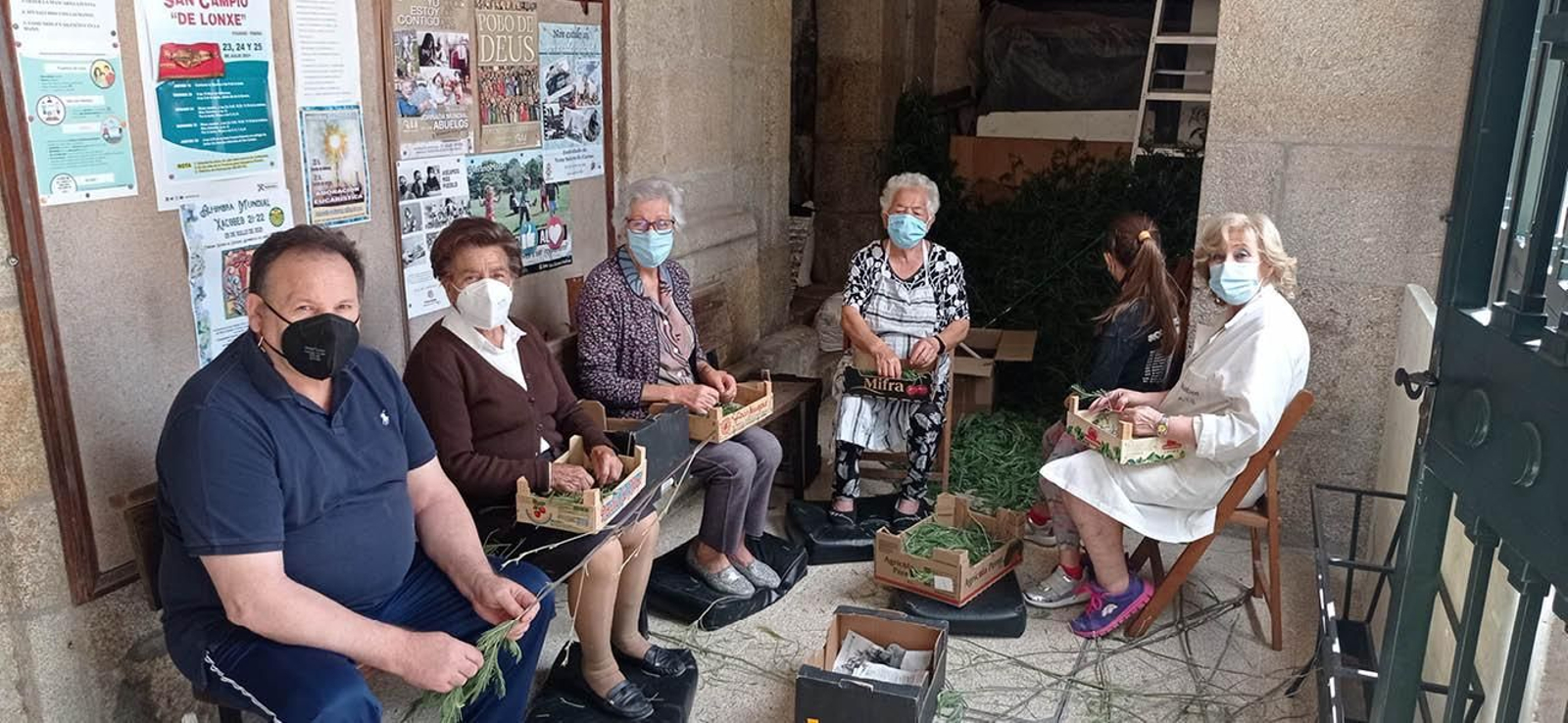 Los más veteranos de la asociación colaboraron activamente en el deshoje de las flores necesarias para hacer hoy la alfombra.