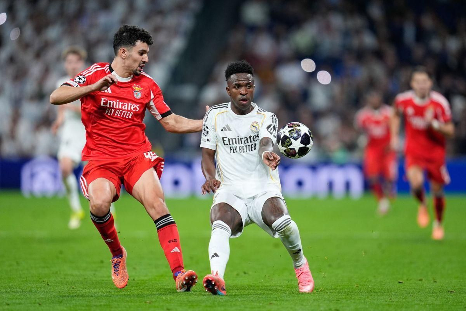 Vinícius y Araujo pelean por el balón en el duelo entre el Real Madrid y el Benfica.