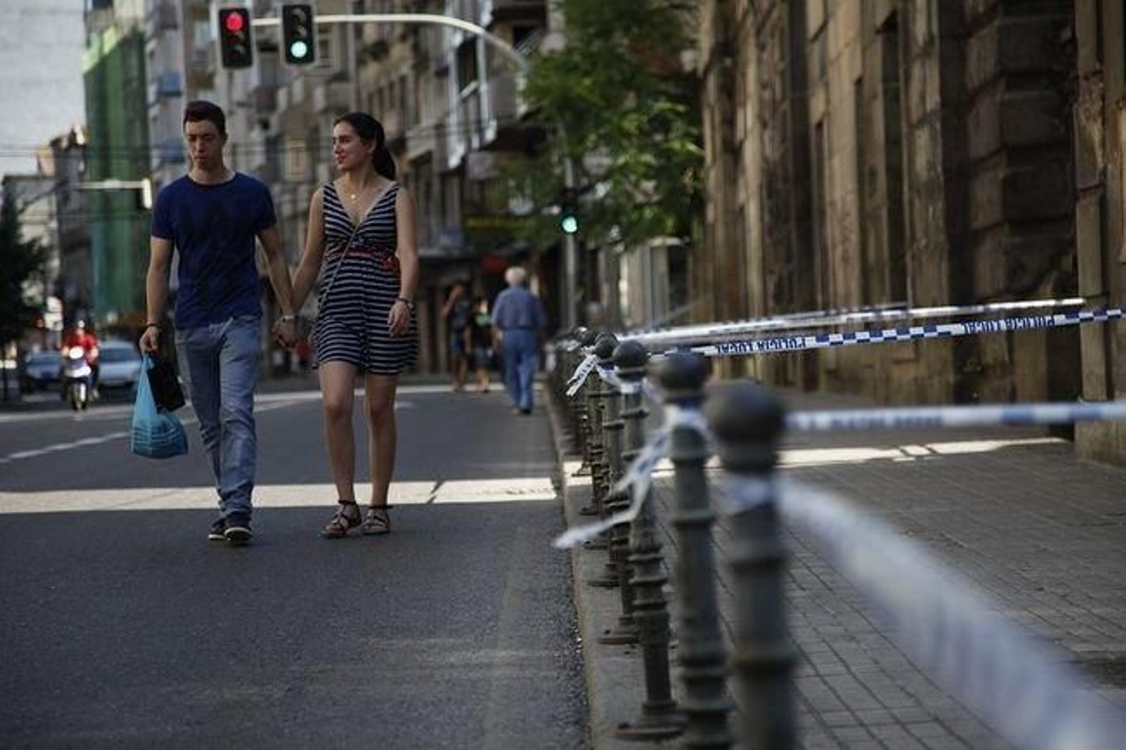 Una pareja sortea el precinto colocado por la Policía Local en la rúa Progreso.