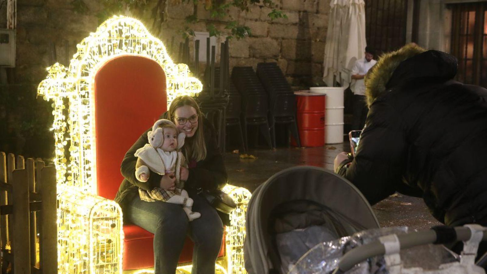 Un niño y su madre se fotografían en la silla de Papa Noel.