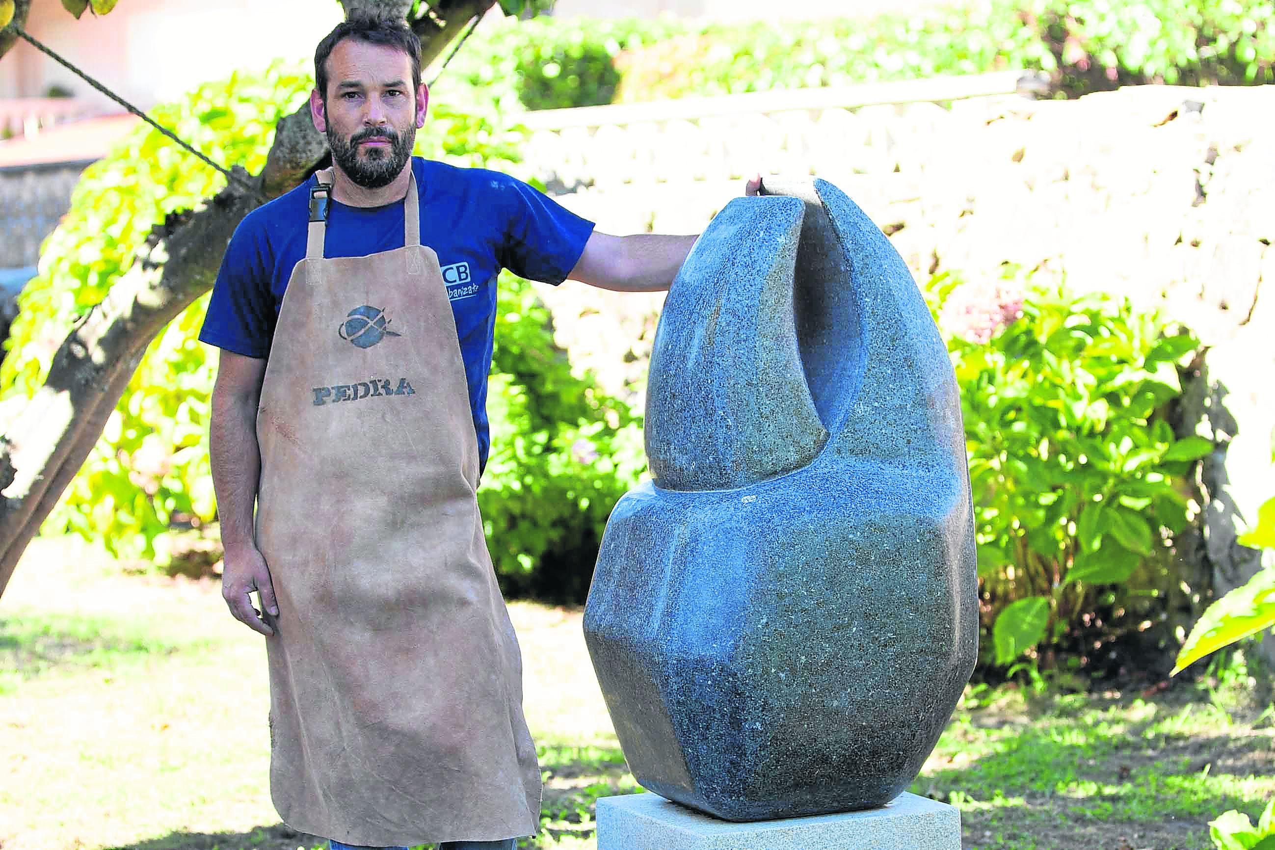 Rodrigo García, junto a una escultura de granito diseñada y creada por él