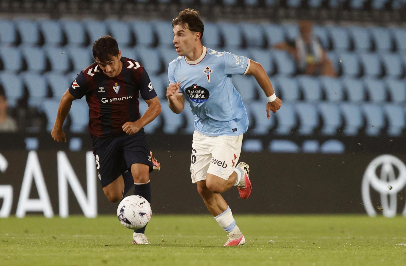 El jugador céltico Adrià Capdevila conduce un balón mientras Ander Madariaga le persigue.