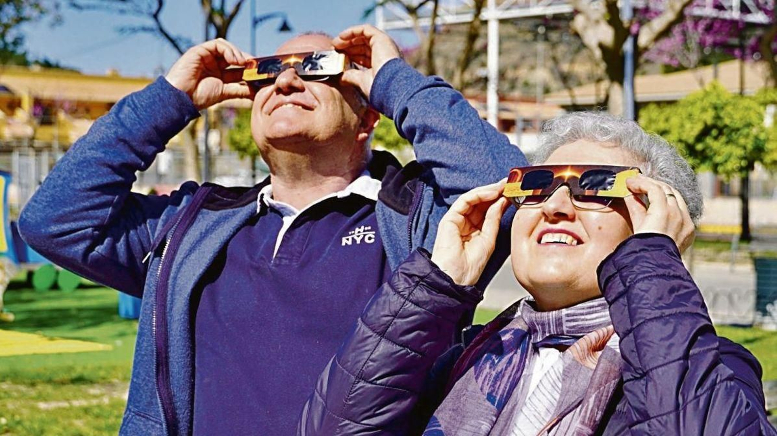 Dos personas prueban las gafas que usarán el día del eclipse.