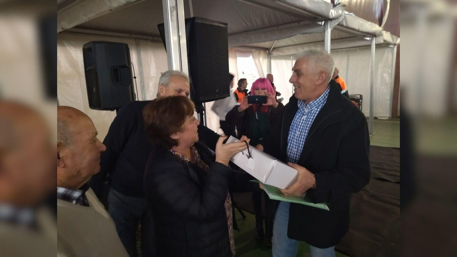 Uno de los voluntarios, Isidro Estévez, recoge el obsequio de manos de la alcaldesa.