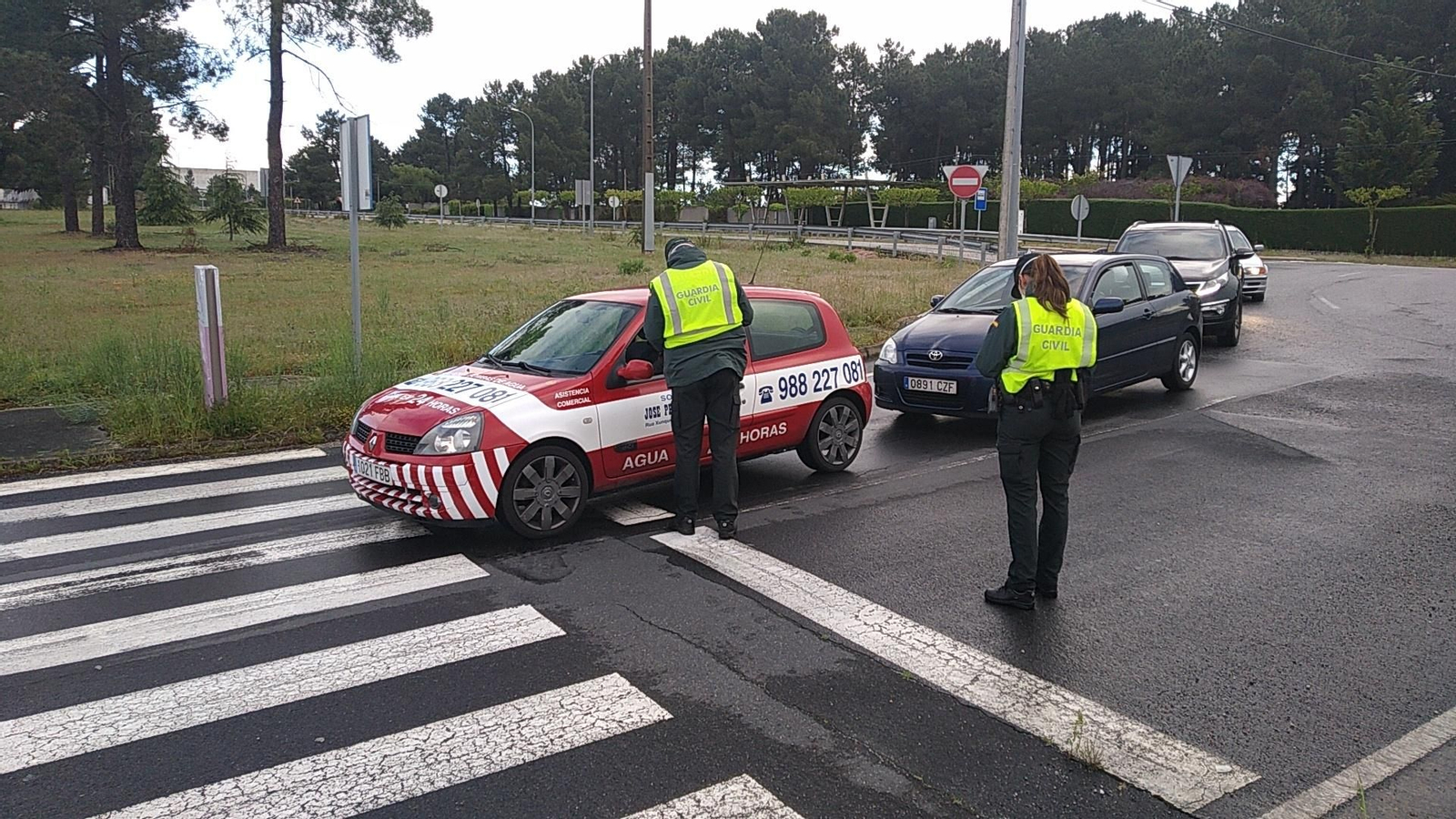 Una pareja de la Guardia Civil entrega mascarillas a la entrada del parque empresarial de Pereiro.