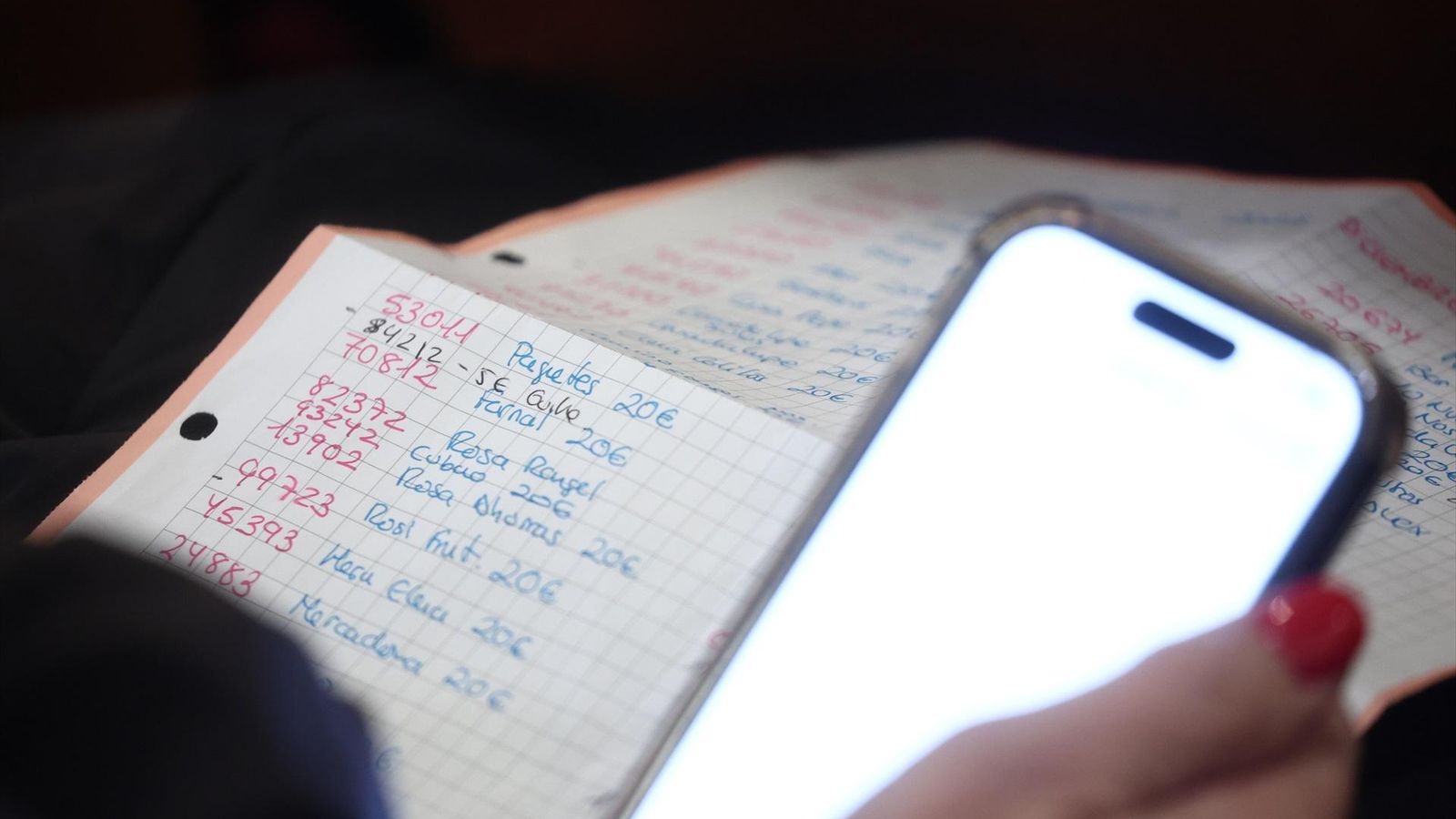 Una mujer revisa la lista de todos los números jugados para ver si tuvo suerte.