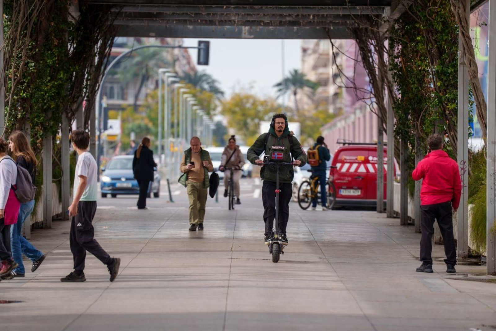 Un usuario de patinete eléctrico circula por una calle de Sevilla sin casco.