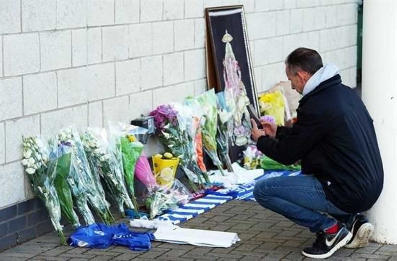 Un aficionado deja flores en el estadio del Leicester.