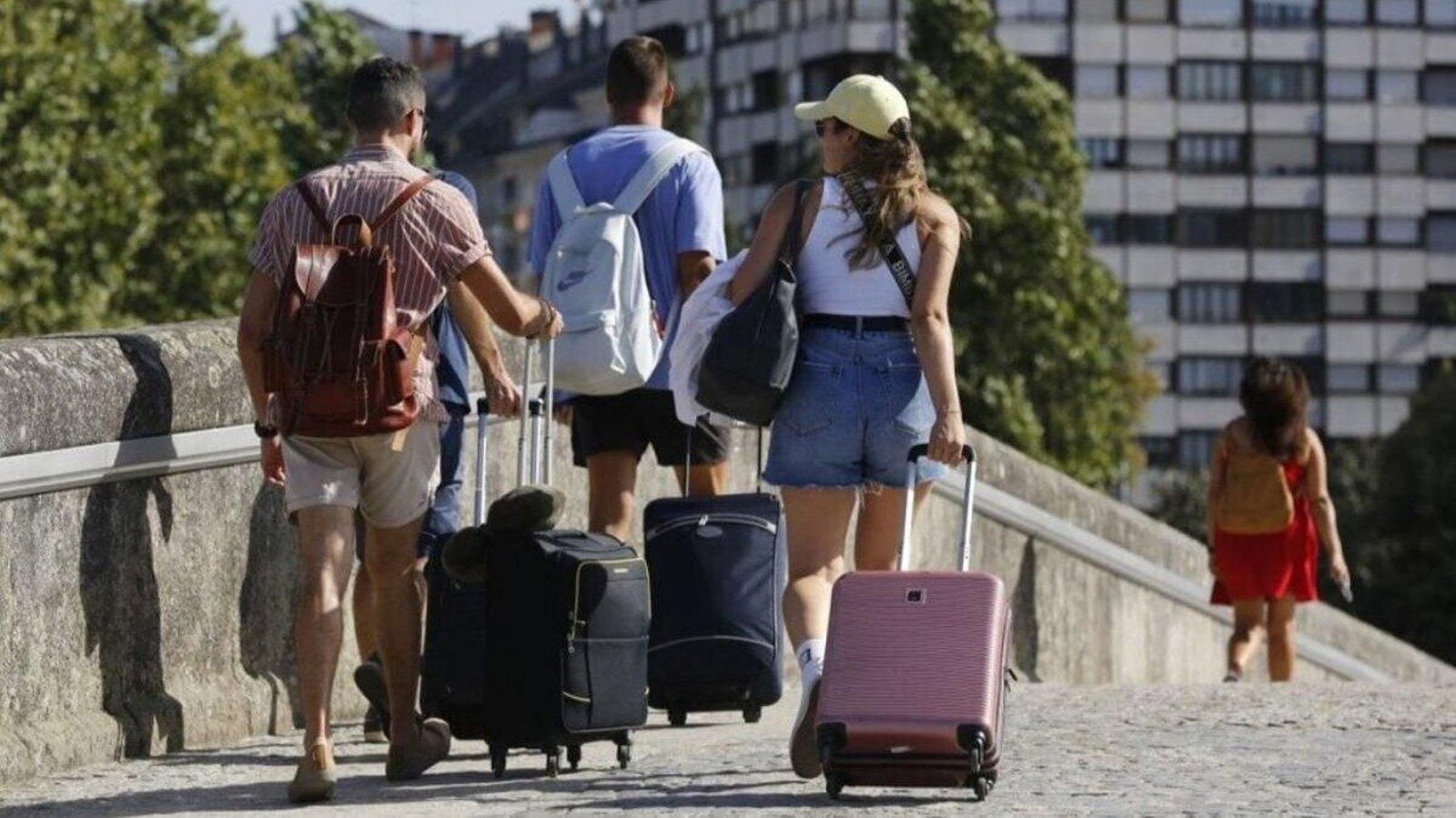 Un grupo de viajeros cruza el Puente Romano, en Ourense.