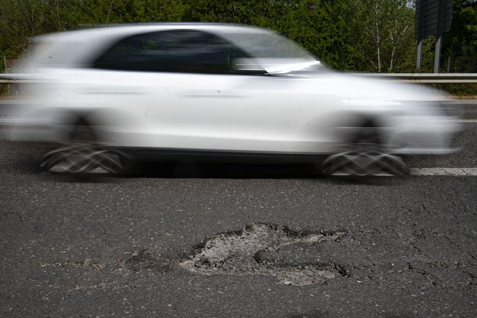 Un turismo evita uno de los múltiples baches que hay en la N-120.