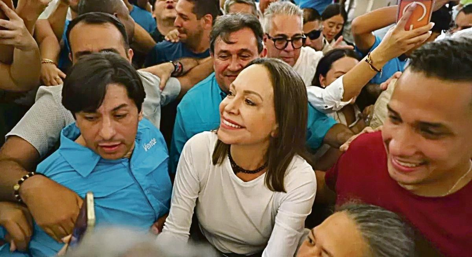 María Corina Machado, rodeada de seguriores de su partido, tras su llegada al país.