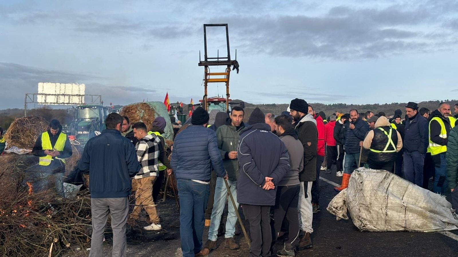 Más de un centenar de personas y sus vehículos cortan la carretera, utilizando rollos de paja y fuego para impedir el paso.