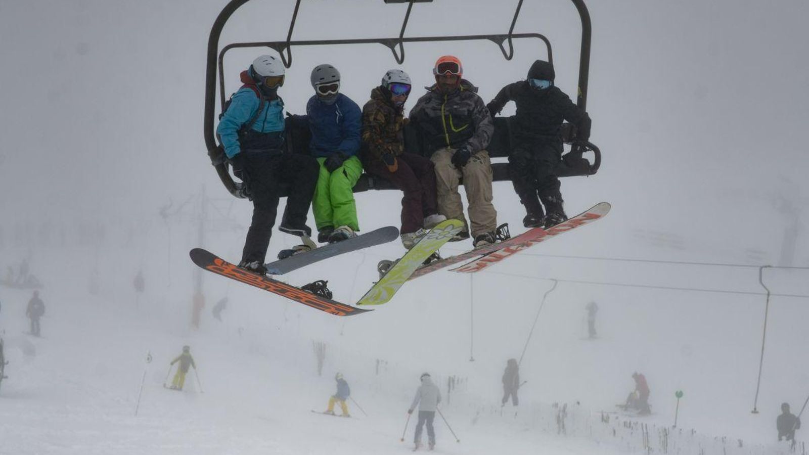 Amantes de la nieve subiendo a la cima para lanzarse en los esquís.