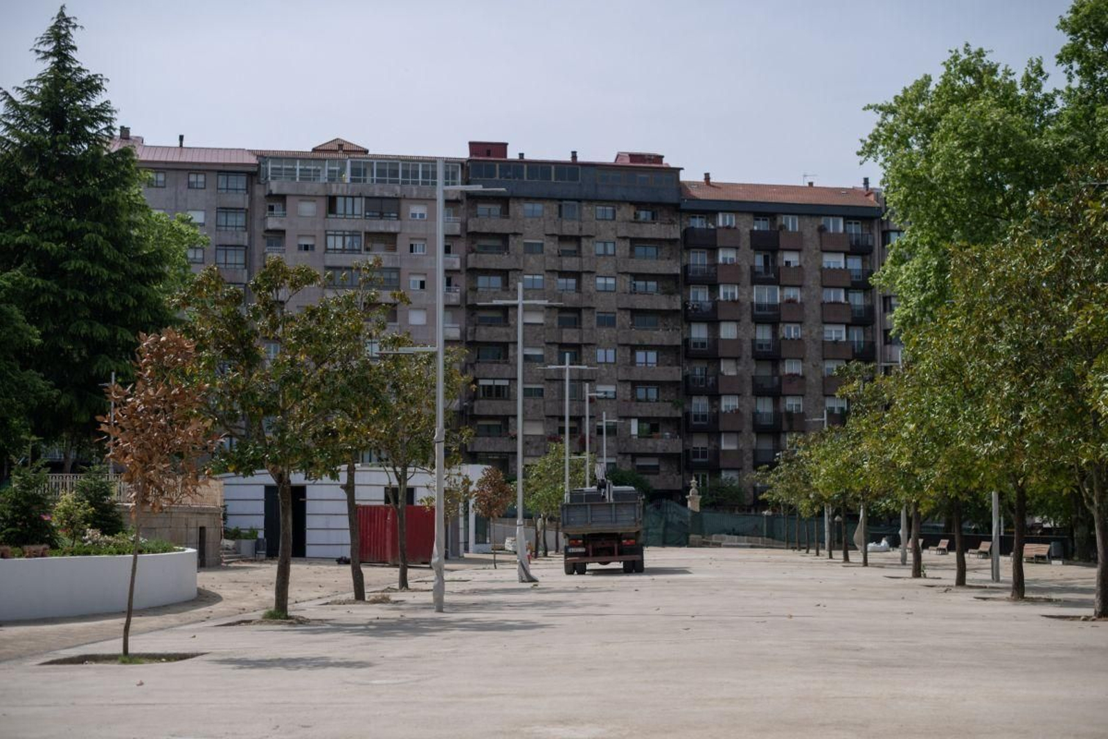 Un camión de la obra pasa por la esplanada de cemento